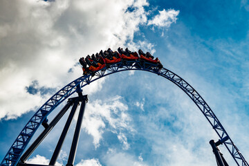 Ride roller coaster in motion in amusement park - obrazy, fototapety, plakaty