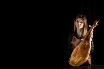 young woman holding a Full leg of Spanish jamon iberico, Jamon Serrano, Bellota, Italian Prosciutto Crudo or Parma ham