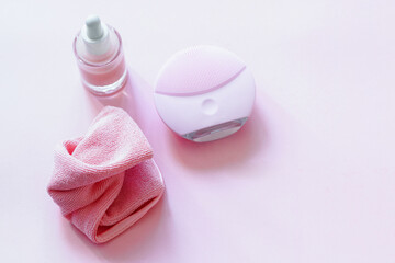 Obraz na płótnie Canvas Cleanser device, natural serum and cleansing cloths on pink background. Perfect Cleansing Routine concept.Copy space