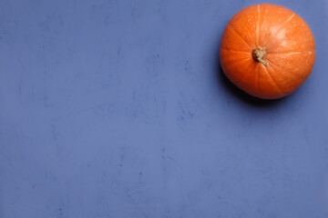 Fresh orange pumpkin on purple background, top view with copy space