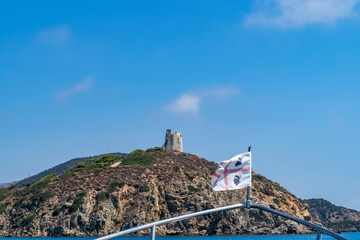 Beautiful view of the southern Sardinian sea from the boat. Note the historic Saracen tower on the...