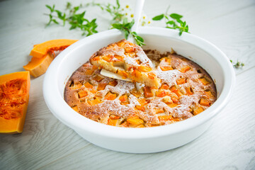sweet pumpkin pie with pumpkin slices in a ceramic mold