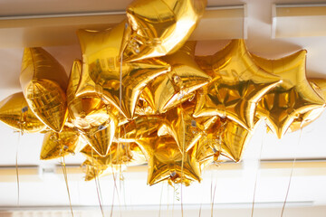 a lot of balloons made of gold foil in the form of stars. September 1