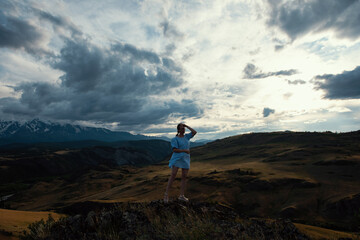 Fototapeta premium Woman in blue dress in summer Altai mountains in Kurai steppe