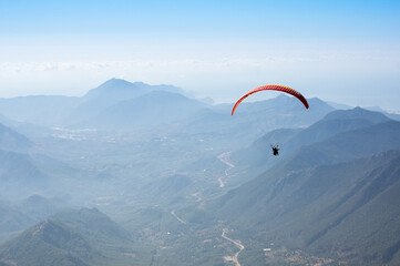 Paraglider flying over mountains