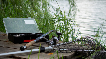 Fishing tackle on the river bank, bait rod, spinning rod, fish. Selective focus