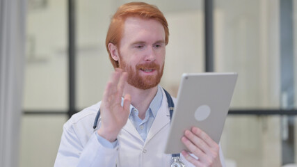 Video Chat on Tablet by Redhead Male Doctor