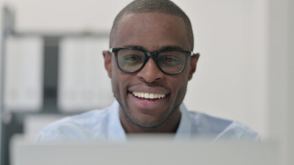 Close Up of Excited African Man using Laptop 