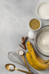 Ingredients for banana bread in bowls on light gray background top view