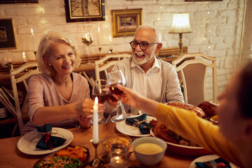 Happy family toasts during dinner at dining table on Thanksgiving.