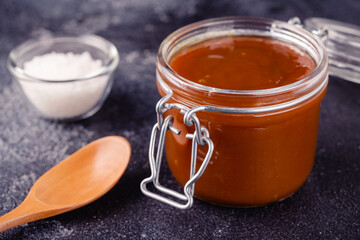 Glass jar with tasty delicious salted caramel