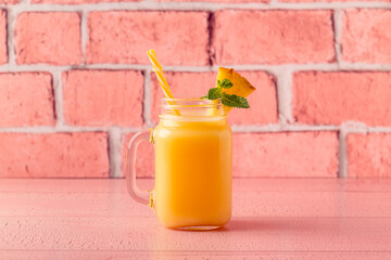 Tropical pineapple smoothie in a mason jar.