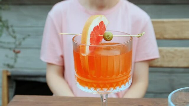 Young woman drinking cocktail in glass. Slow motion.