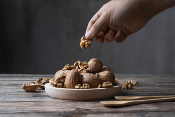 Cogiendo una nuez de un plato lleno de nueces