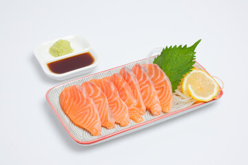 Salmon sashimi on plate with soy sauce and wasabi