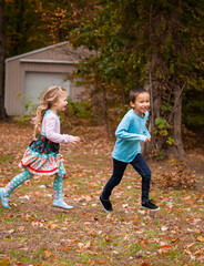 Fototapeta premium Sister chasing brother in fall