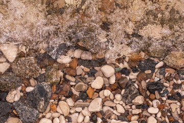 Rocks at the bottom of the river in close-up. The wave hits the rocks. Stones underwater 