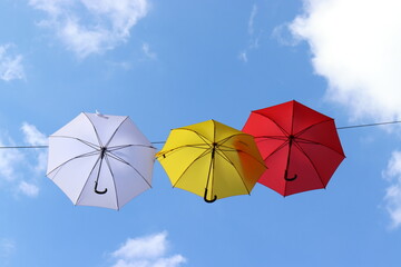 Bunte Regenschirme vor blauem Himmel.