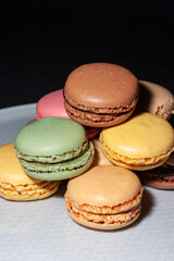 Macarons de colores sobre fondo negro. Concepto gastronomía repostería. 