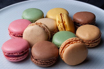 Macarons de colores sobre fondo negro. Concepto gastronomía repostería. 