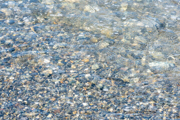 Background of wet pebbles washed by a sea wave