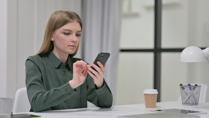 Attractive Young Woman using Smartphone at Work 