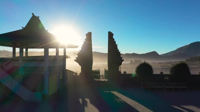 Cinematic shot , aerial view of Pura Luhur Poten hindu temple near Mount Bromo volcano in East Java, Indonesia during sunrise