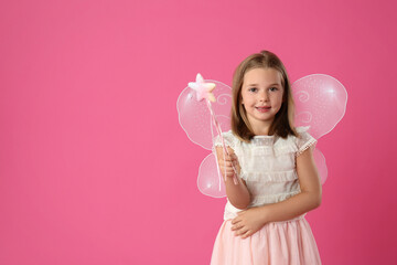 Obraz na płótnie Canvas Cute little girl in fairy costume with wings and magic wand on pink background. Space for text
