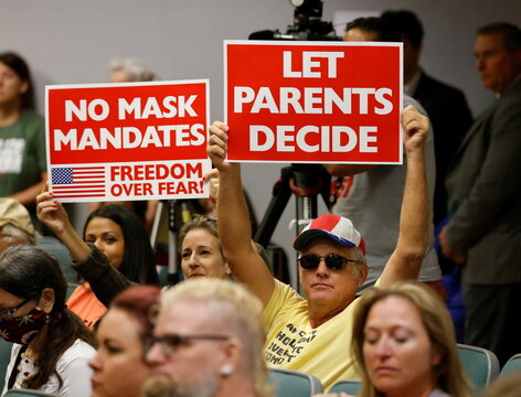 Residents hold placards as members of the Lake County School Board conduct an emergency meeting to discuss mask mandates to prevent the spread of coronavirus disease (COVID-19) in Tavares