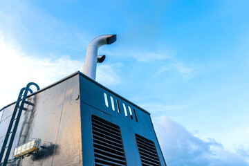 The exhaust pipe of the ferry against the sky. Black exhaust smoke