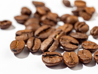 Brown roasted coffee beans on a white background.