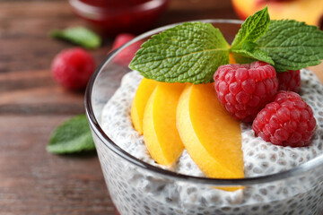 Delicious chia pudding with raspberries, peach and mint in glass, closeup