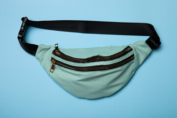 Belt bag on blue background. Top view of casual waist bag