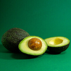 Fresh organic avocado on a green background.