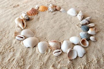 Sea stones and seashells on white sand at sunset. Copy space, Resumption of tourist trips, recovery from the crisis