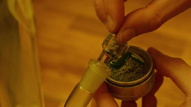 Close up smoking medical marijuana with bong. 4k video. CBD cannabis buds grinded 
