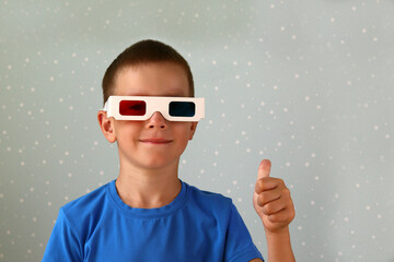 A boy in 3D glasses on a gray background