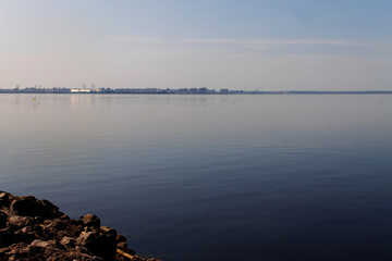 a rocky shore and a calm bay stretching into the horizon