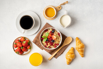 Continental breakfast with granola, croissant, jam, chocolate spread and coffee with milk. Top view