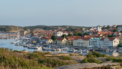 Fototapeta na wymiar Marstrand island panorama Scenery with Harbour and boats in the canal and Carlsten's fortress against the blue sky in west caost of Sweden.