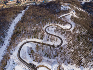 Winter aerial view of the road to ski resort Krasnaya Polyana. Beautiful winter landscape from drone.