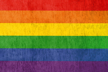 LGBT flag colors on the background of a textured wall. Freedom Month, transgender people in communities concept.