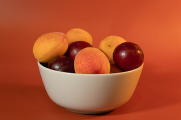 Fruit in a plain light bowl on a plain surface. Healthy vegetarian food