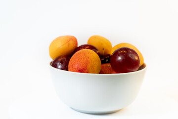 Fruit in a plain light bowl on a plain surface. Healthy vegetarian food