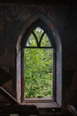 Ogival window in old ruined abandoned historical mansion in Gothic style