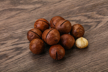 Brown macadamia nut heap over background