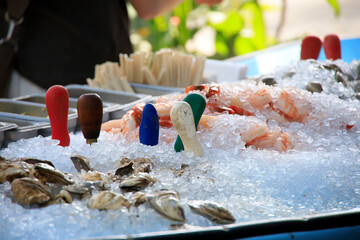 Fresh seafood sitting on a pile of ice at a raw bar