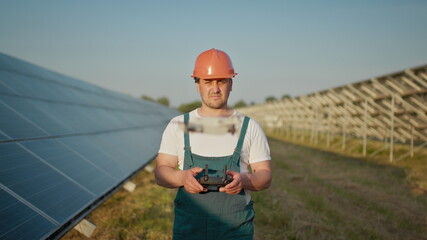 An employee of a solar power plant talks on a walkie-talkie while his colleagues and an investor...