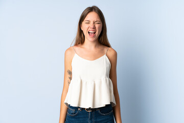 Obraz premium Young Lithuanian woman isolated on blue background shouting to the front with mouth wide open