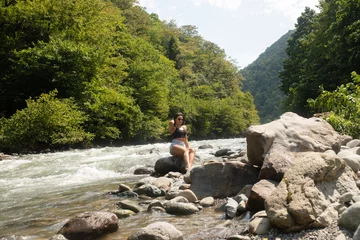 Foto op Plexiglas Young black woman tourist relaxes in river. © lashkhidzetim